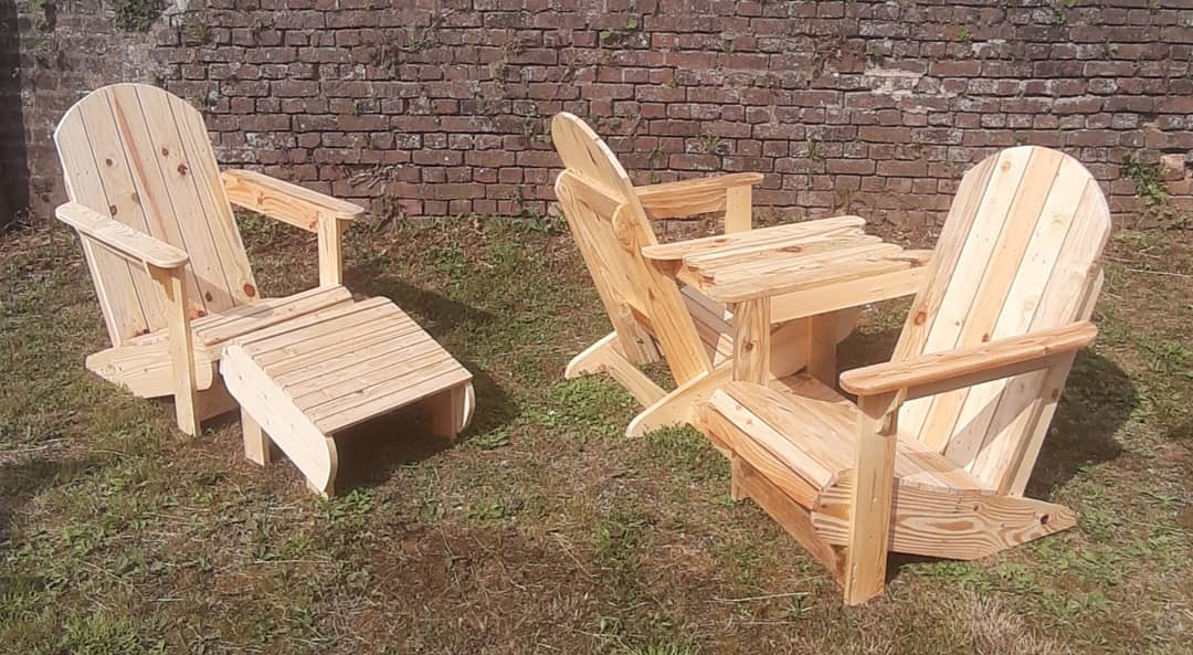 Fauteuils Adirondack et repose-pieds en pin, sur la pelouse devant un mur de briques