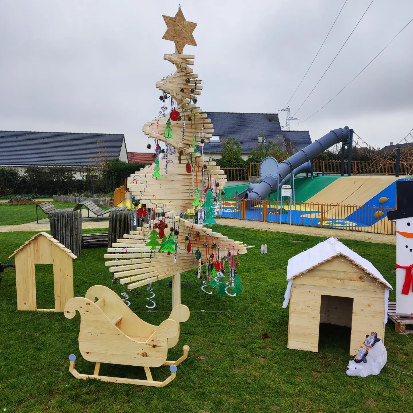 Sapin de Noël géant en spirale de palettes recyclées, avec son traîneau